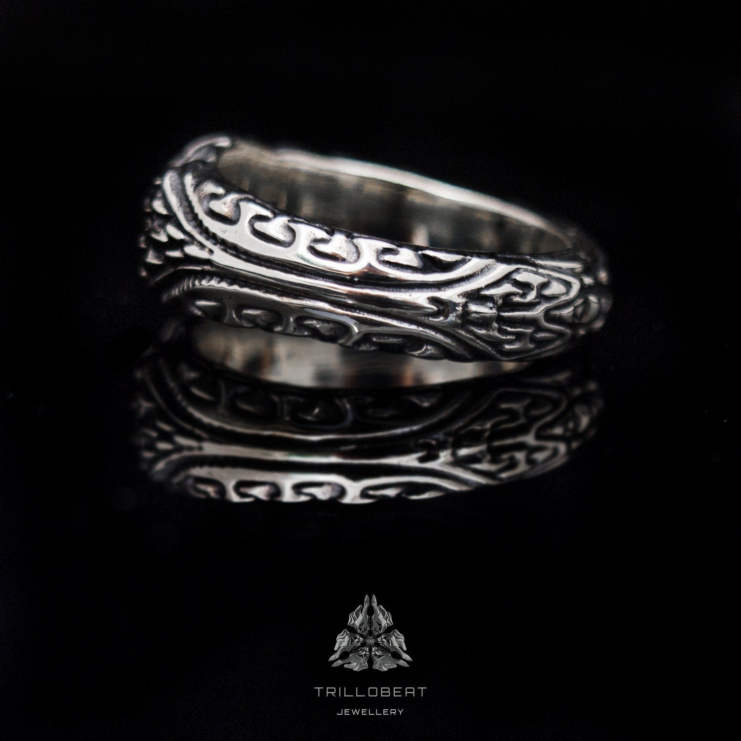 Textured silver ring displayed on dark background