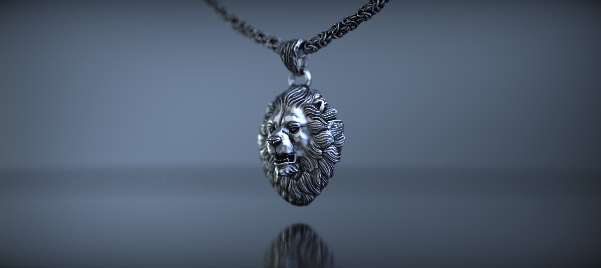 Silver lion head pendant photographed from front angle