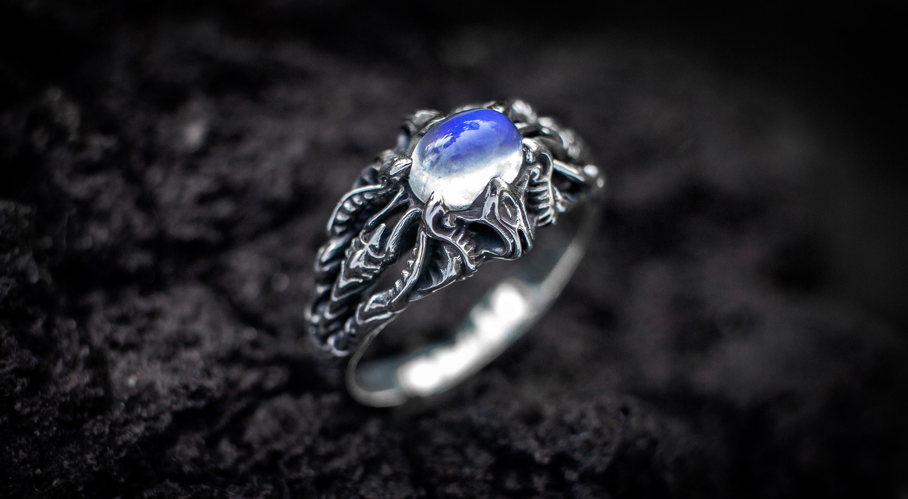 Side view of silver moonstone ring with sculptural band