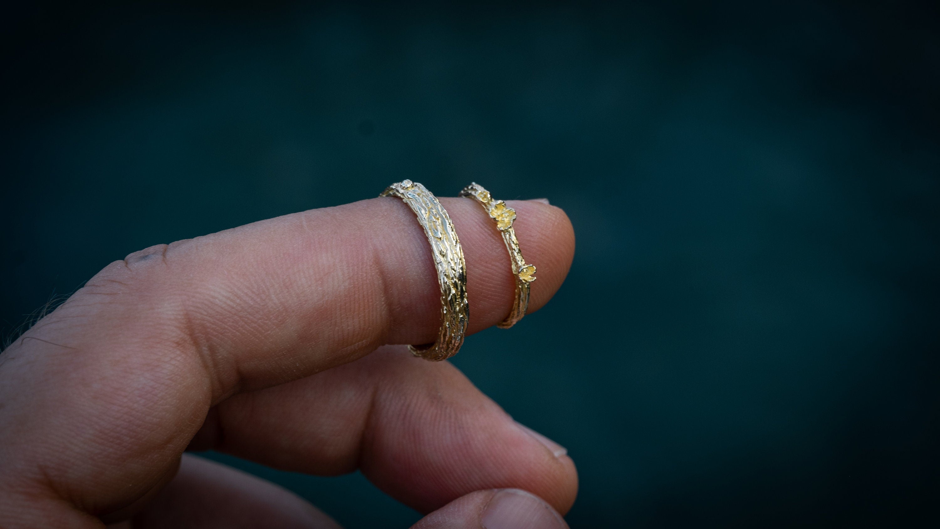 Gold rustic wedding band set displayed with organic texture