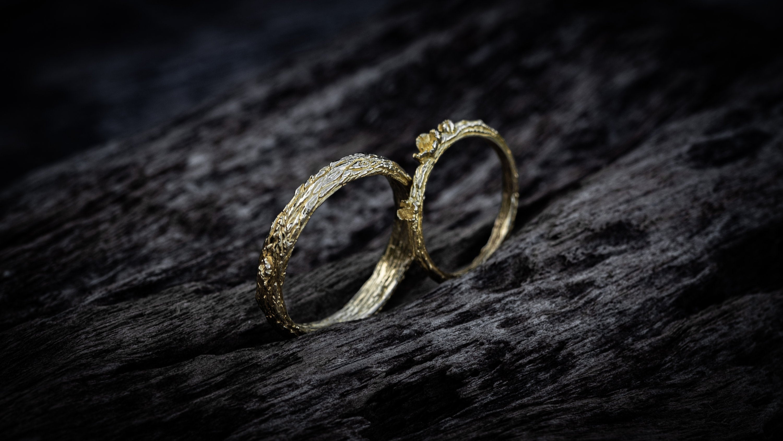 14K gold couple rings photographed as nature-inspired wedding set
