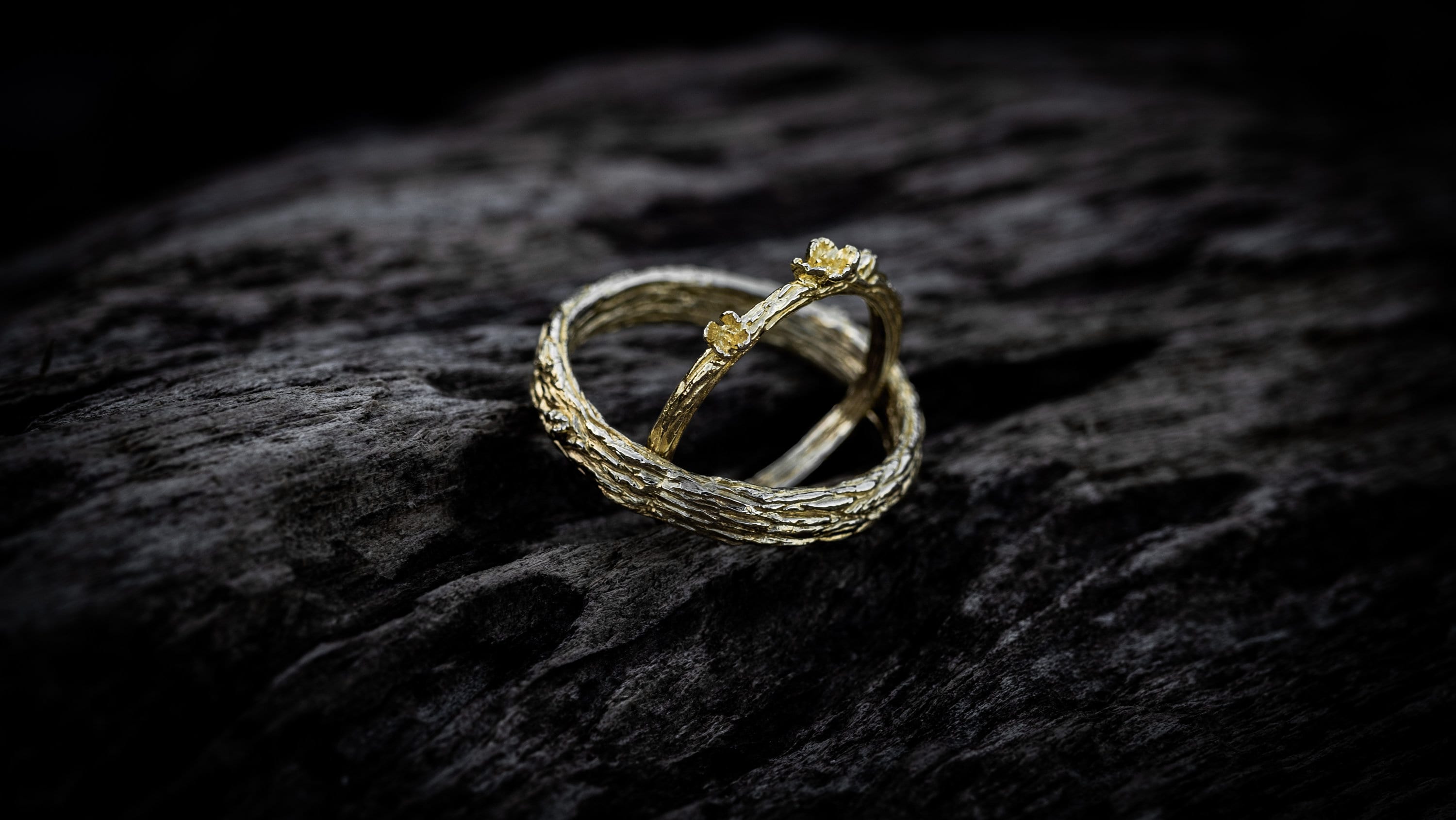 Side view of handmade gold tree bark wedding bands