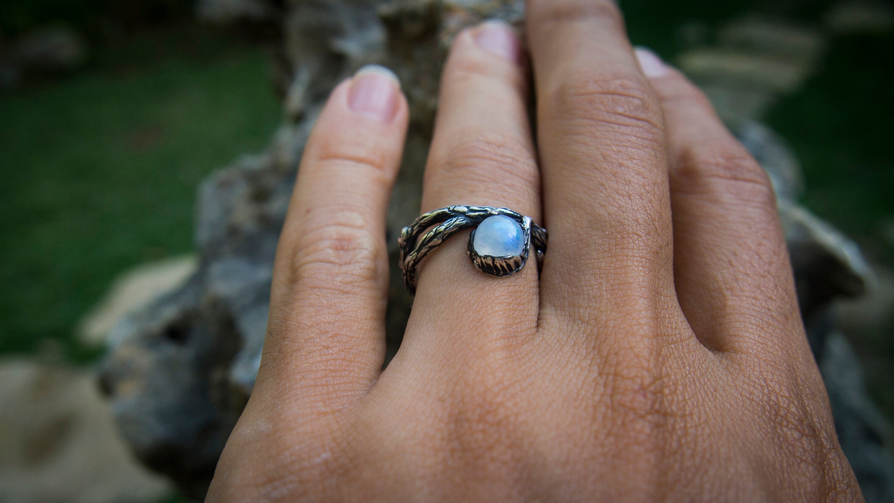 Silver branch engagement ring photographed on dark background