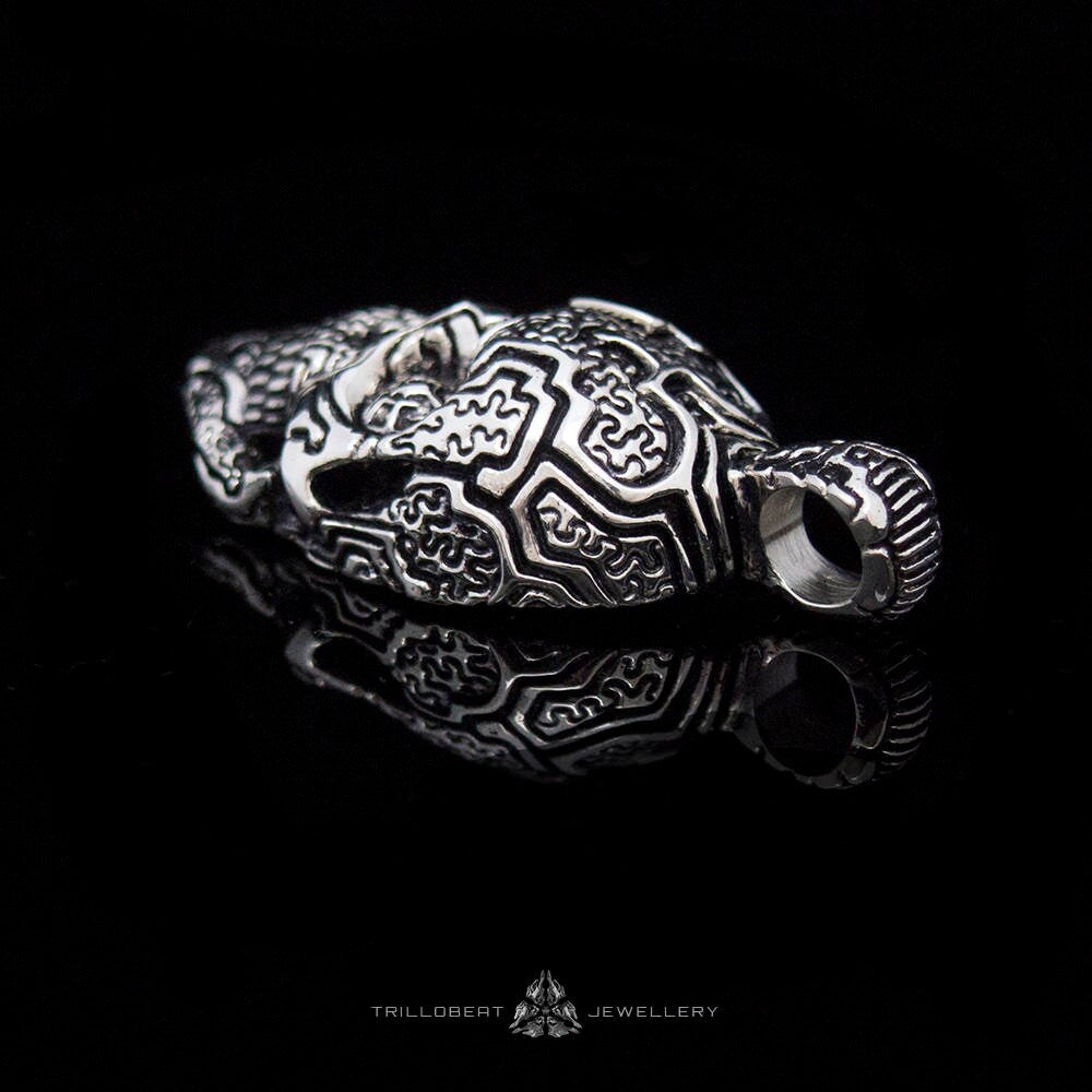 Silver skull pendant with symbolic carved surface texture