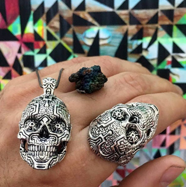 Detailed view of silver pendant with skull and geometric engravings