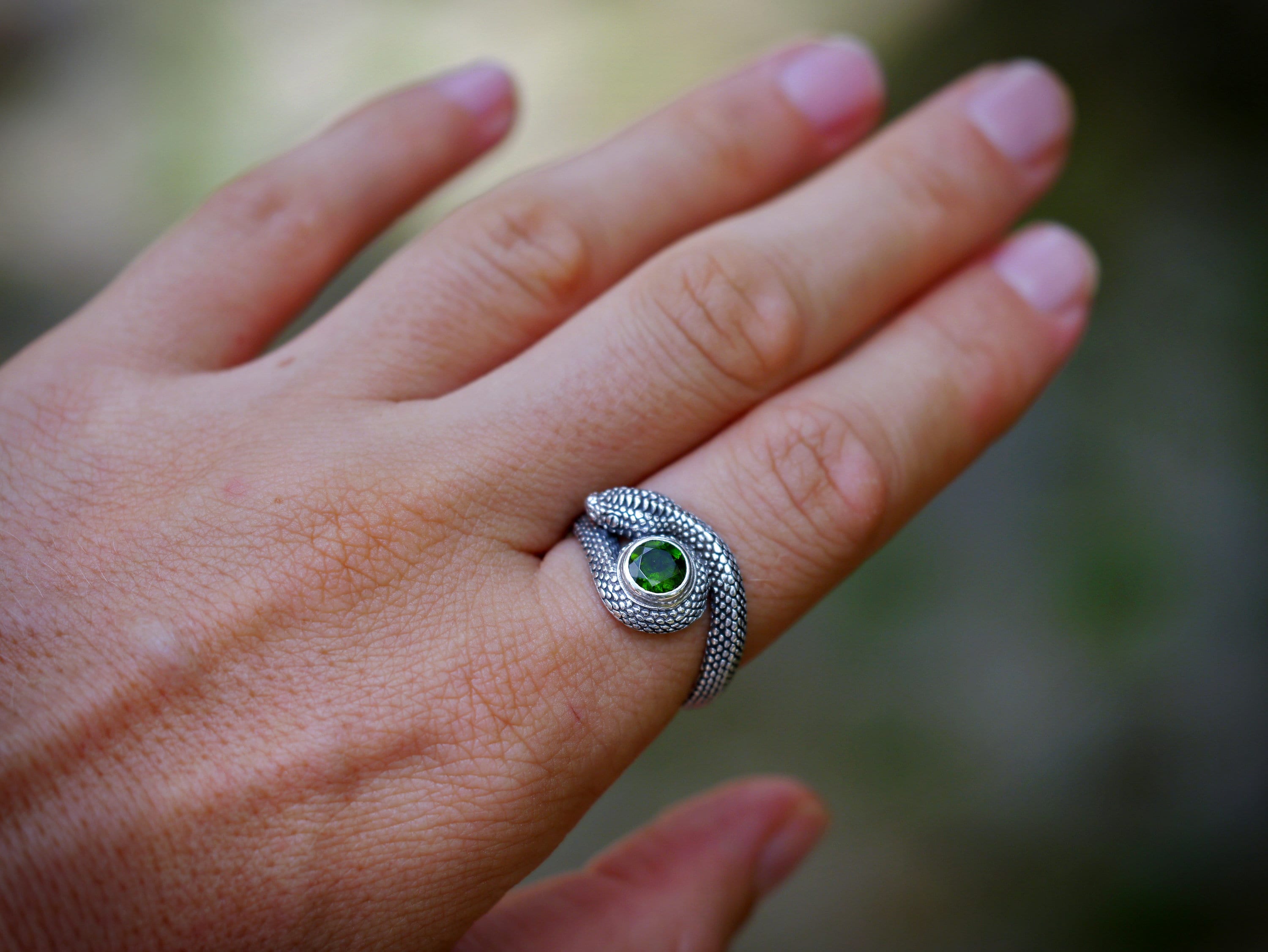 Vertical view of silver serpent ring with gemstone