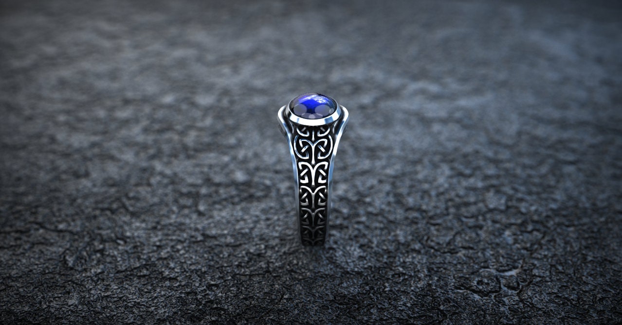 Silver Celtic jewelry with purple gemstone on dark background