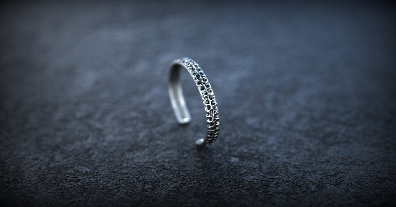 Sterling silver carved bracelet displayed on dark background