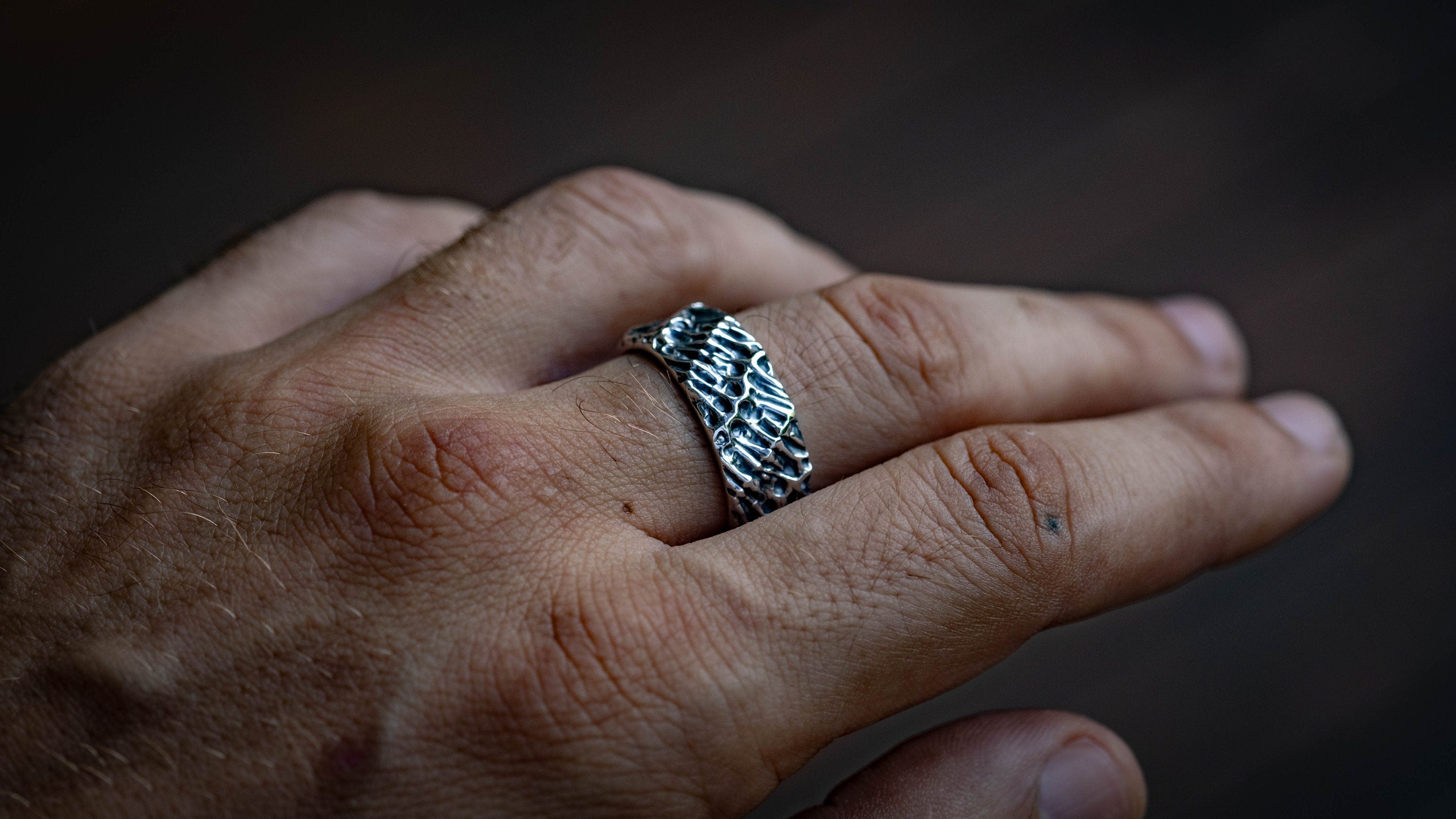 Textured silver ring displayed from side angle