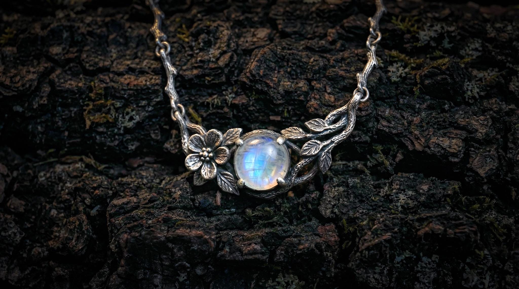 Nature-inspired silver flower pendant photographed from front angle