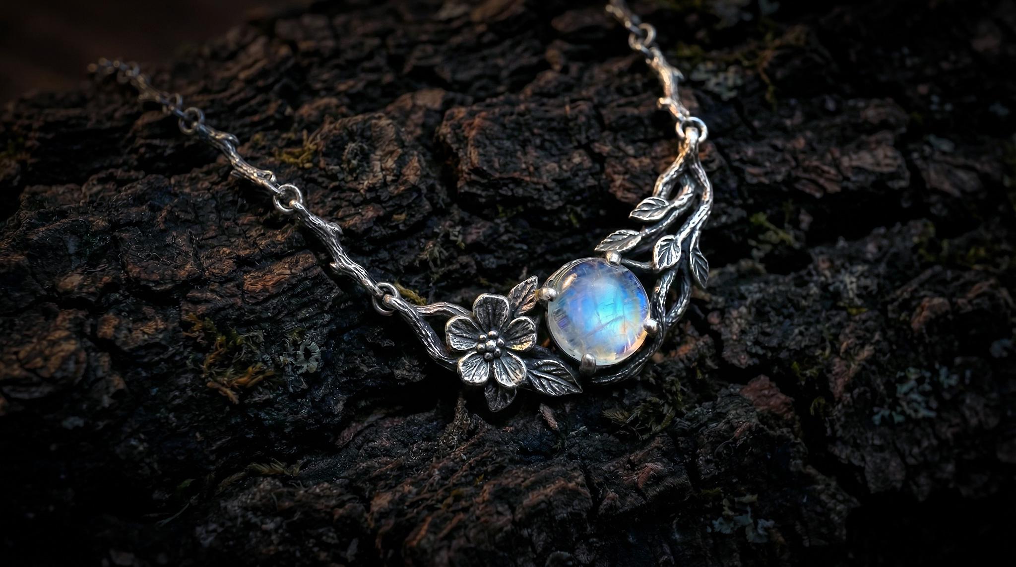 Side view of handmade silver twig necklace with rainbow moonstone