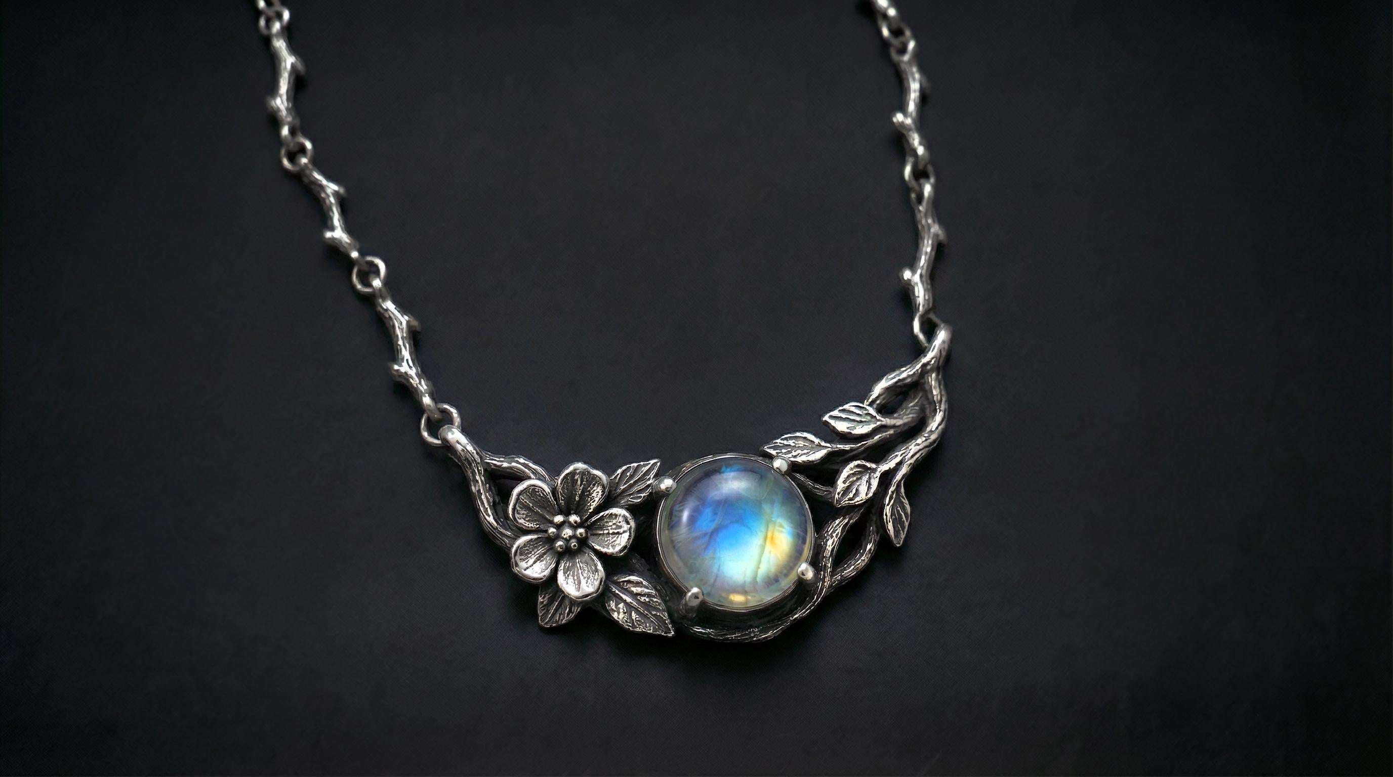 Rainbow moonstone flower pendant on dark background